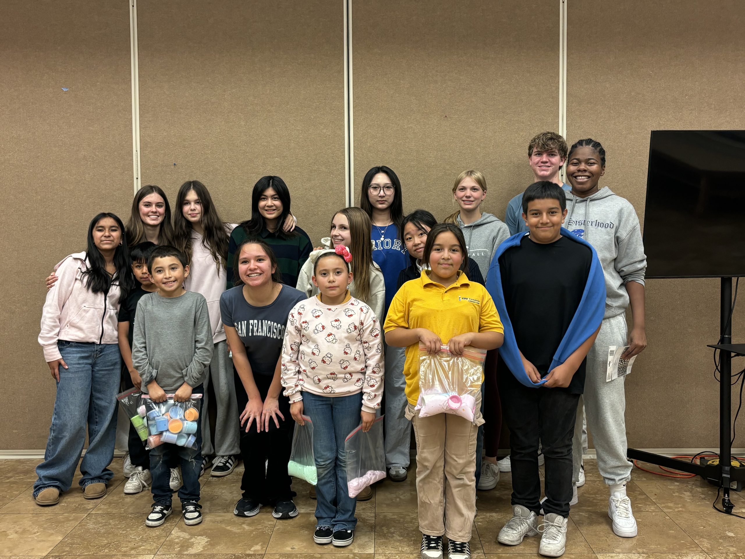 A group photo with 10 high school student mentors and approximately 5 elementary aged students.